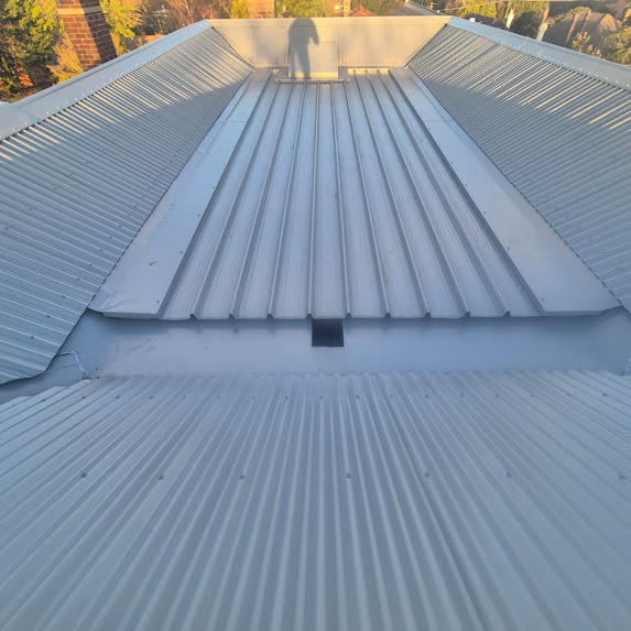 A photograph of a metal roof with a new metal roof cap.