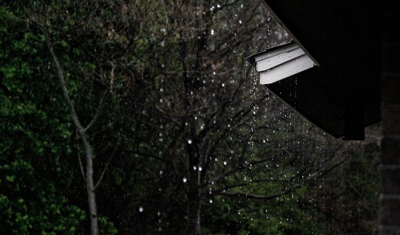 Rain pouring down from a roof during a storm